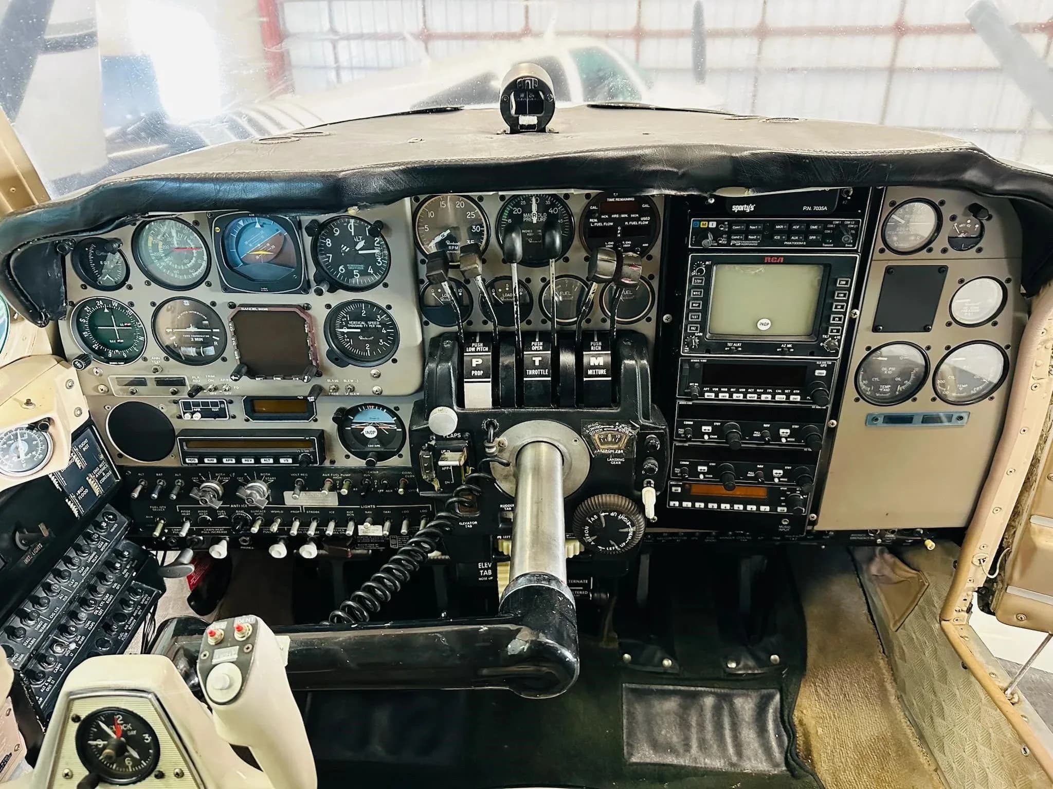 The cockpit of the aircraft, showing the instrument panel with analog gauges and a central yoke.