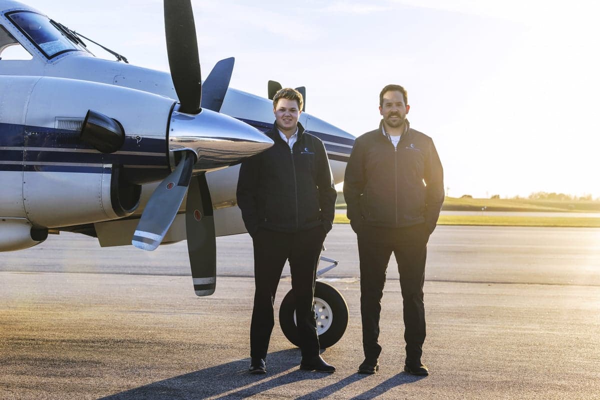 Two men standing in front of a Beechcraft King Air.