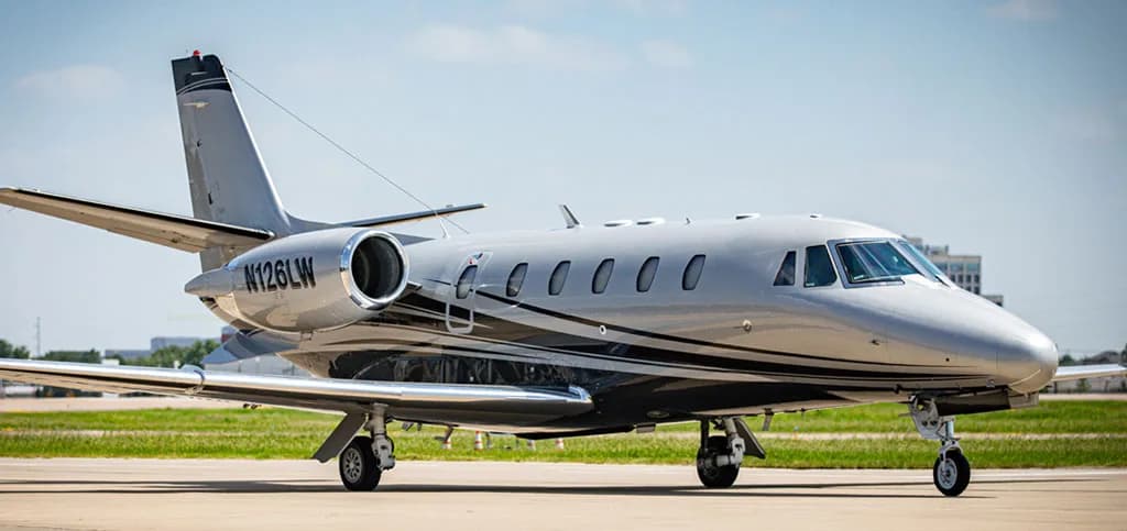 A silver and black Cessna Citation business jet, tail number N126LW, is parked on an airfield.
