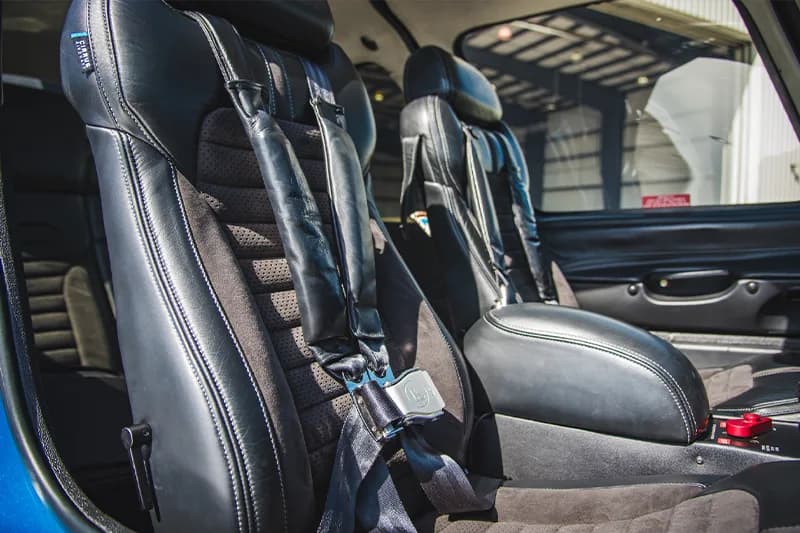 The interior of a Cirrus aircraft, showing the seats and seatbelts.