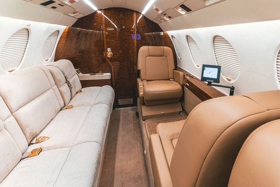 The Falcon 7X cabin offers a mix of seating options, including a couch and individual seats.