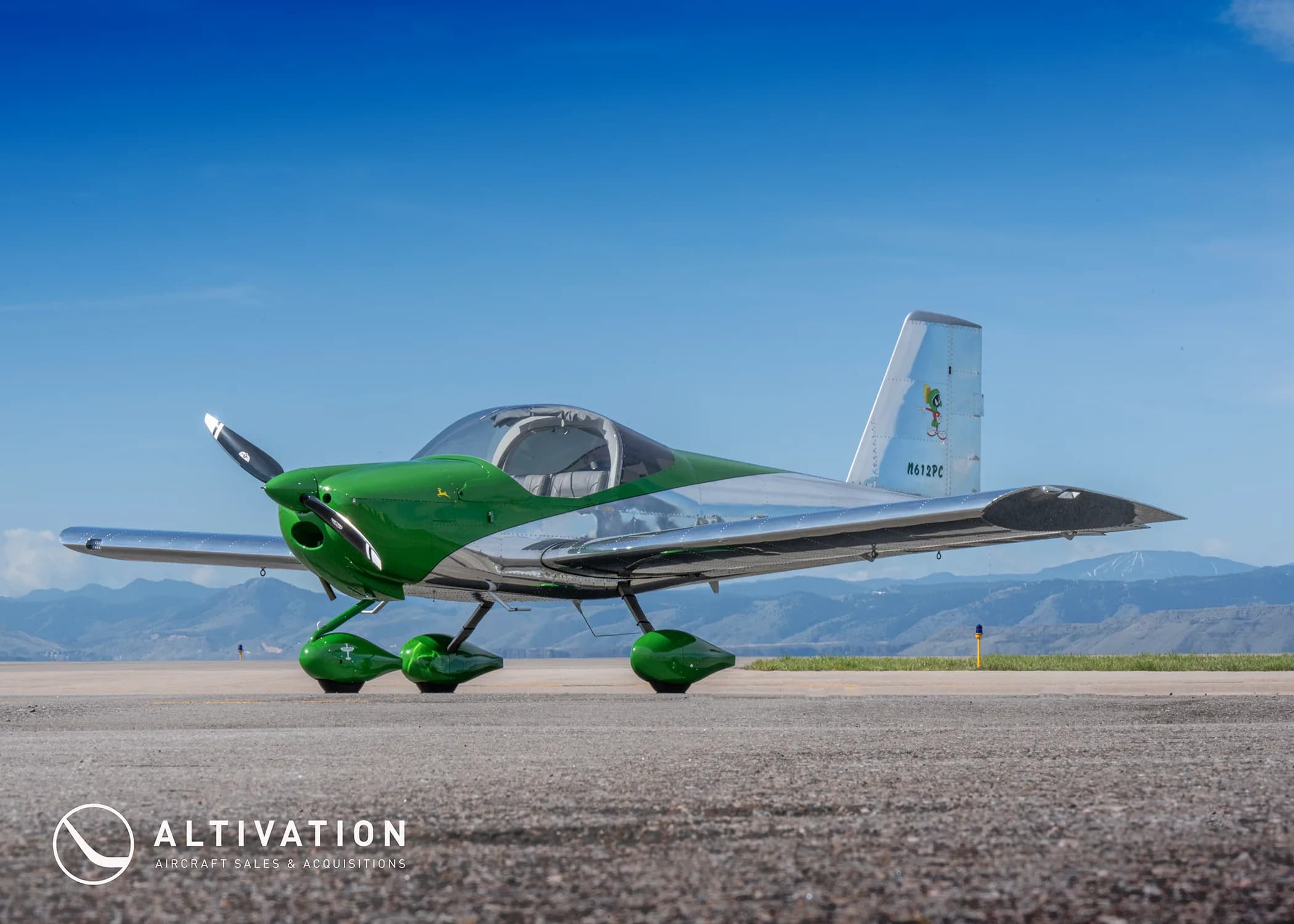 A green and polished aluminum Vans RV-12 aircraft with registration N612PC parked on an airfield.