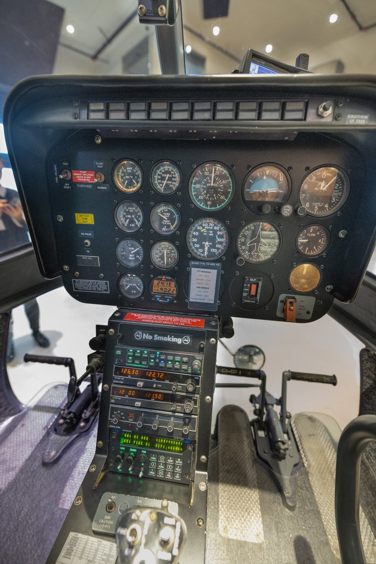 View of the cockpit of a helicopter, including the instrument panel and seats.