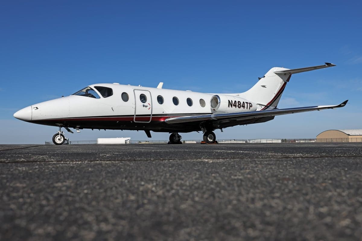 A Hawker 400XP aircraft with registration N484TP is parked on the tarmac.
