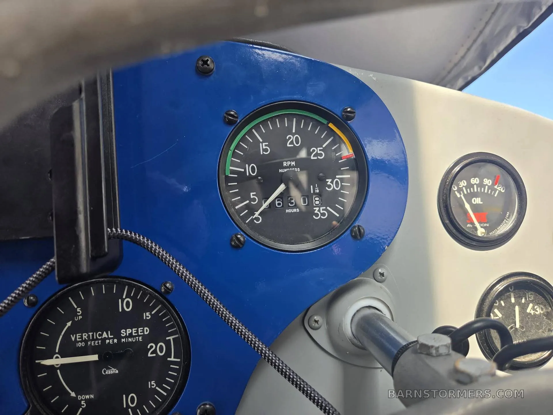 A close-up of the blue-framed RPM gauge and vertical speed indicator in an aircraft cockpit.