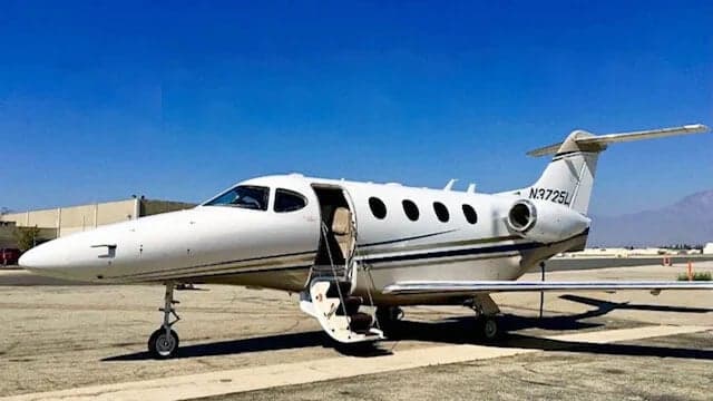 A white jet with registration N3725L parked on the tarmac with the airstair door open.