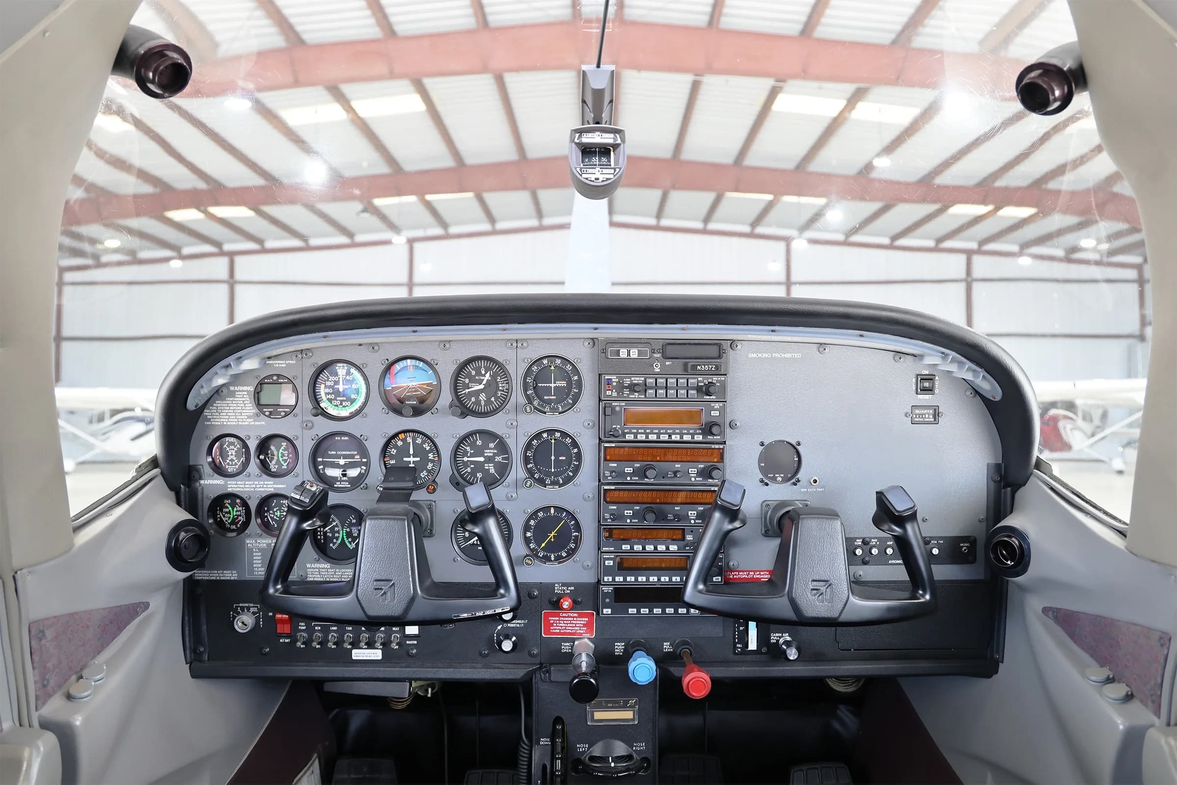 View of the cockpit instrument panel with analog gauges and dual yokes.