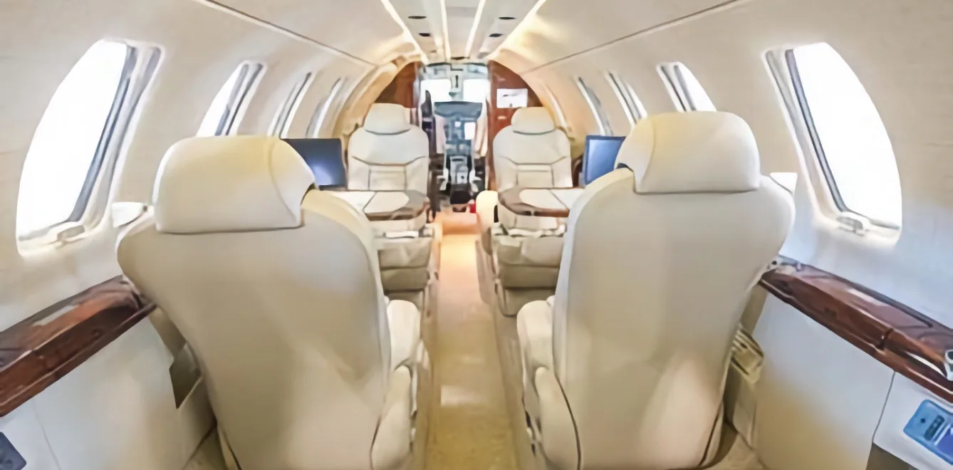 View down the aisle of an aircraft cabin with leather seats.