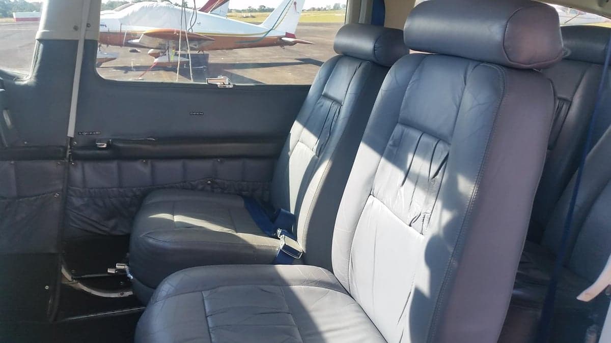 View of the aircraft's gray leather seats with another aircraft visible through the window.