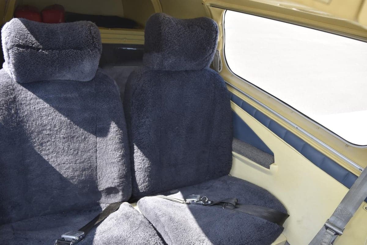 View of the aircraft's seats with sheepskin covers and side window.