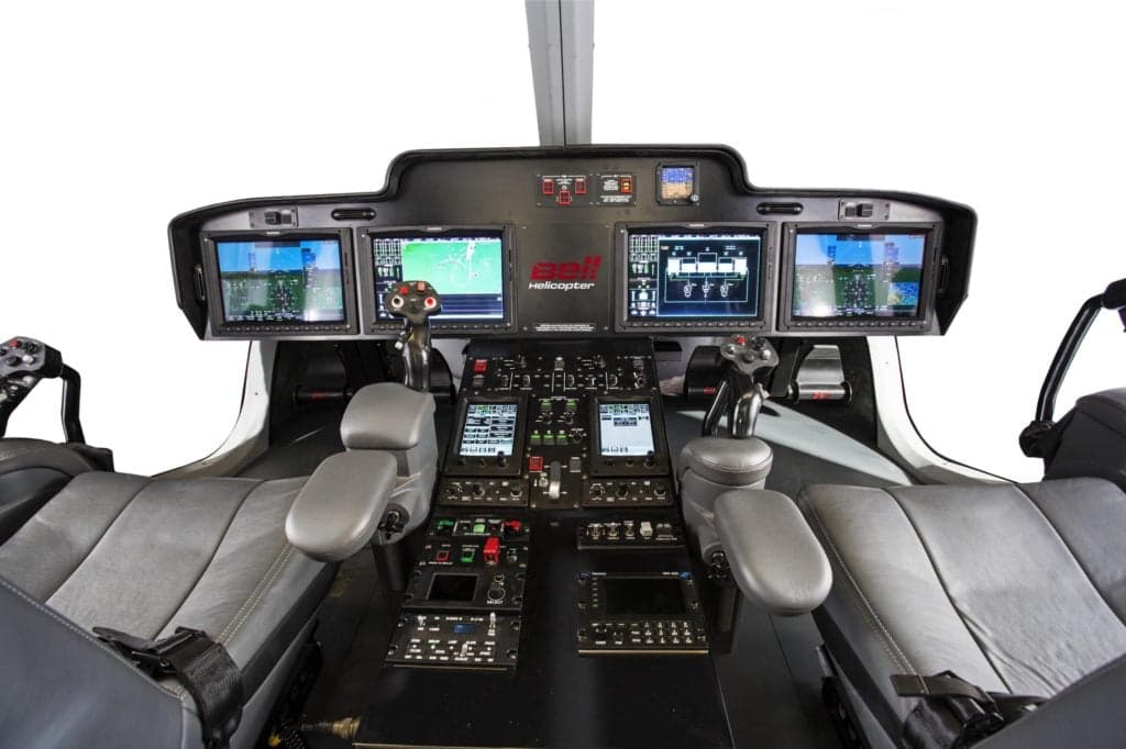 The cockpit of a Bell helicopter with multiple display screens.