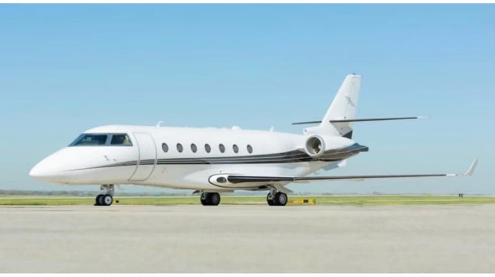 A white and black aircraft is parked on the tarmac.