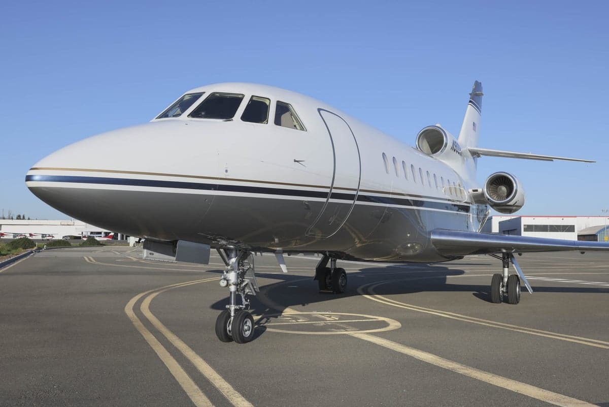 Front view of the N900MK Falcon aircraft on the tarmac.