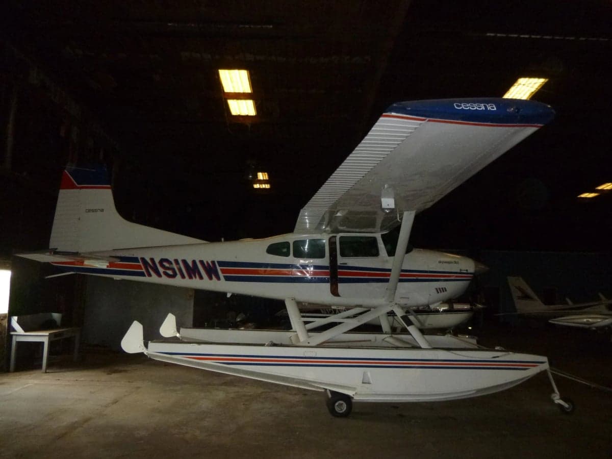 Cessna Skywagon 185 floatplane with registration N91MW in a hangar.