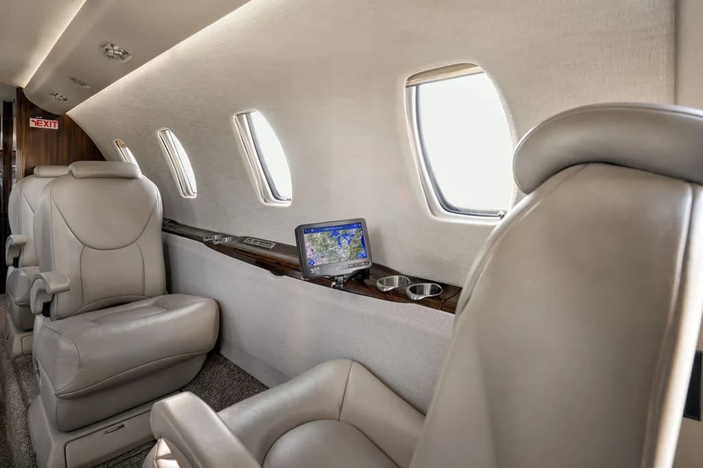 A passenger seat in the aircraft cabin with a personal entertainment screen displaying a map.