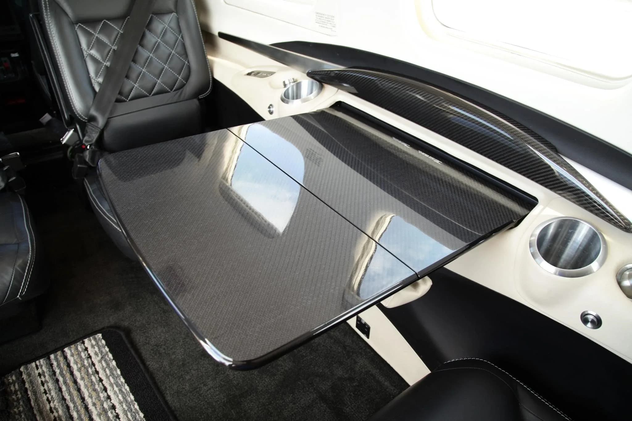 A carbon fiber fold-out table and cup holders in the aircraft's luxurious cabin interior.