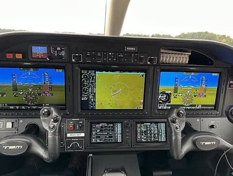 The instrument panel of a TBM 930 aircraft with multiple display screens.