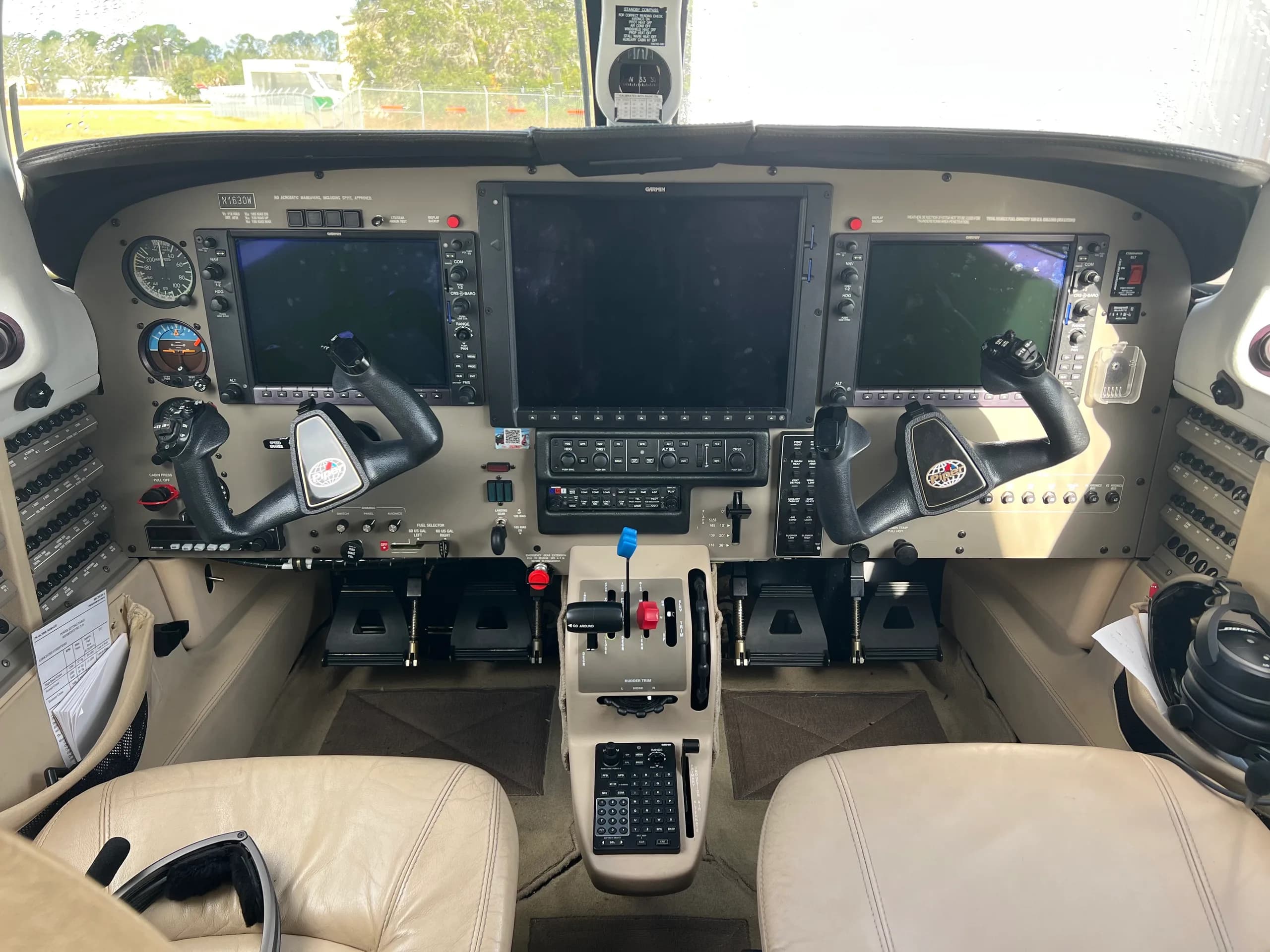 The cockpit of the aircraft, featuring multiple large display screens, control yokes, and a central throttle quadrant.