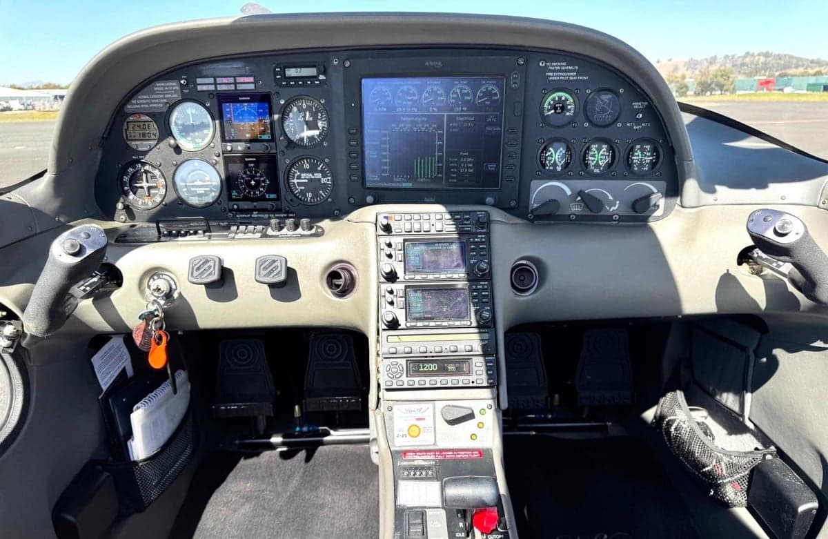 The cockpit of a Cirrus SR20, showing the instrument panel with multiple screens and gauges.