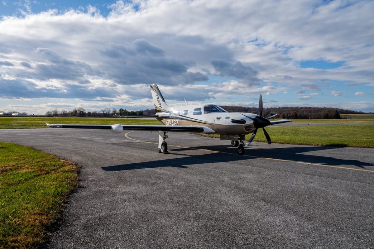 The Fury M700 aircraft is parked on the tarmac with a cloudy sky in the background.