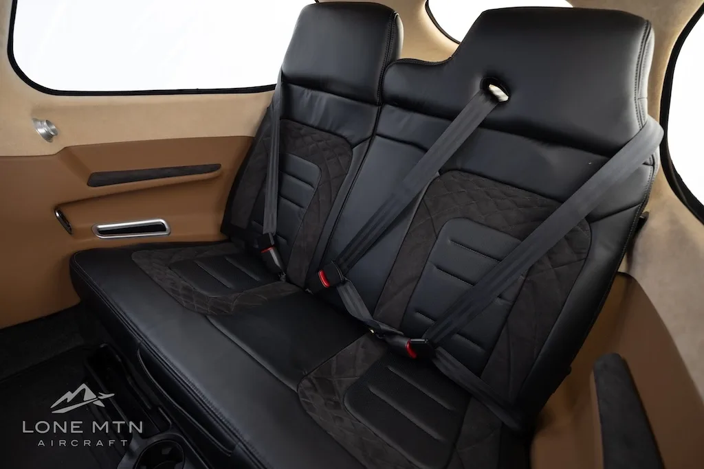 The black leather rear seats with quilted patterns inside the aircraft cabin.