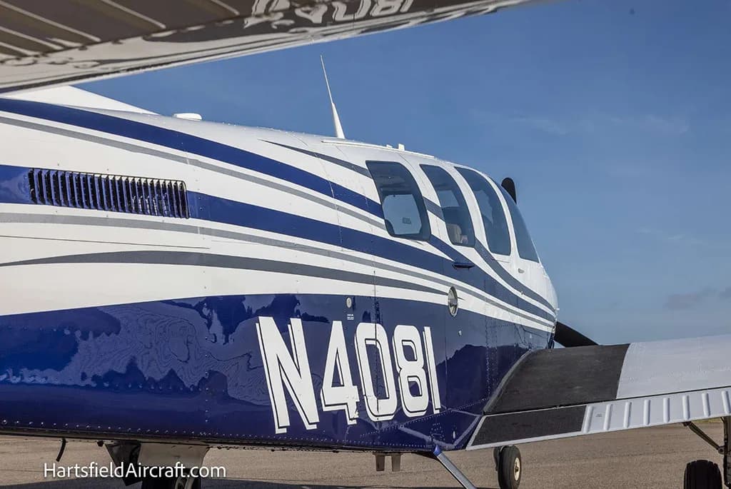 A close-up side view of the blue and white fuselage of Beechcraft Bonanza N4081.