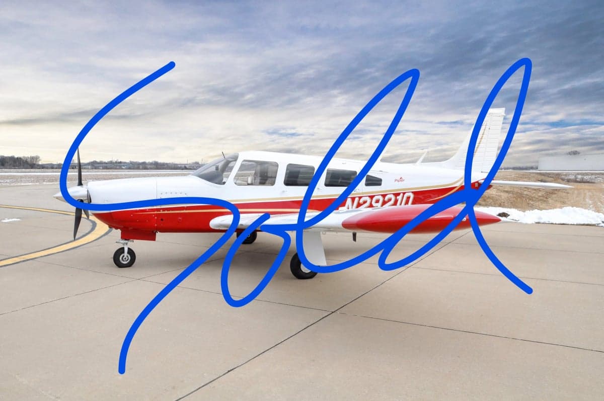 A Piper PA-28-181 Archer II aircraft with a red and white paint scheme is parked on the tarmac.