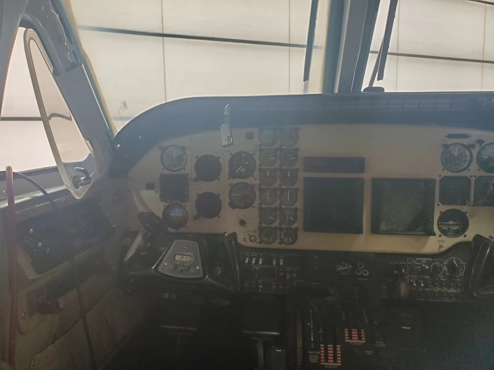 A wider view of the Beechcraft King Air 90 cockpit, showing the instrument panel, yoke, and throttle quadrant.