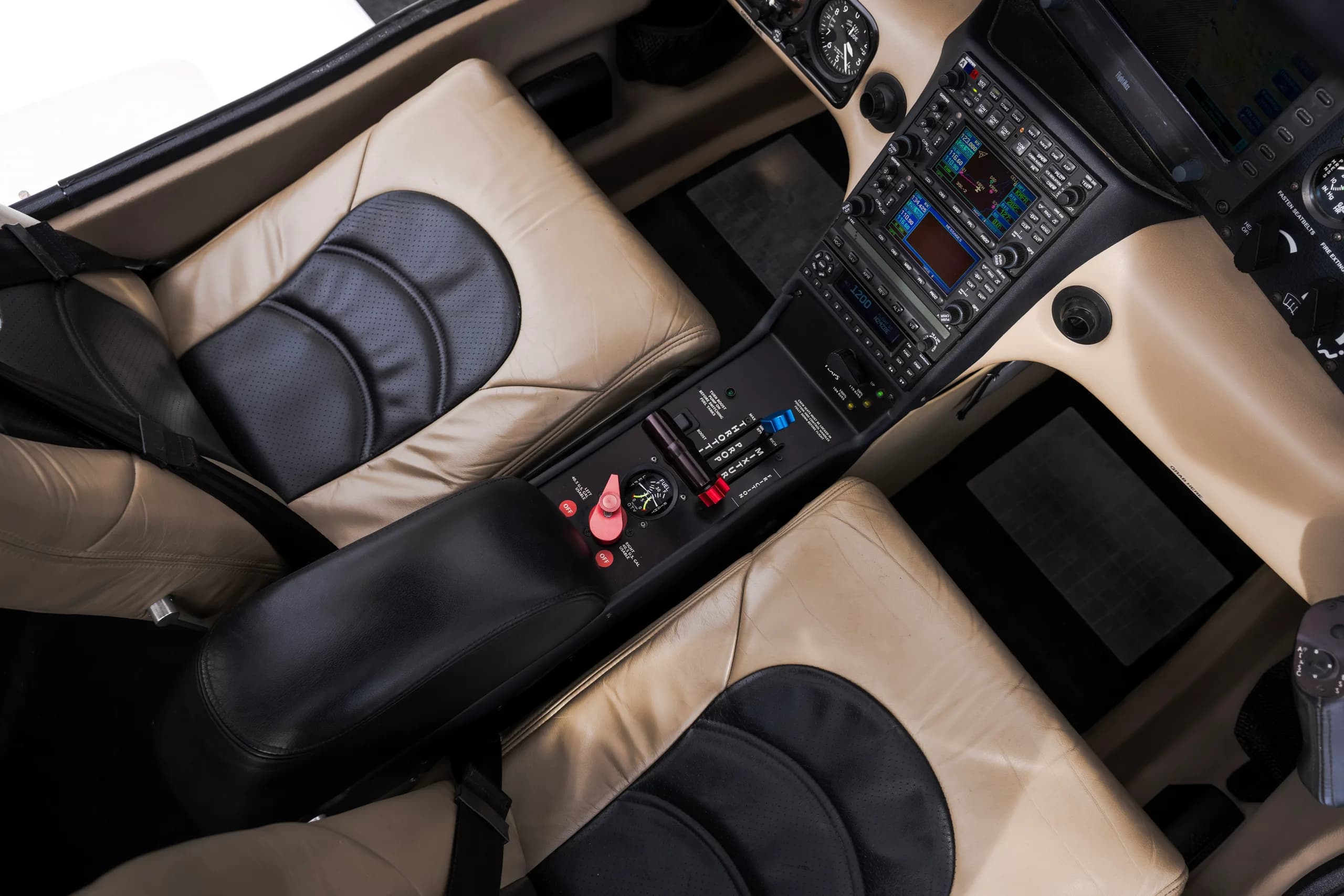 An overhead view of the aircraft cockpit, showing the center console, controls, and front seats.