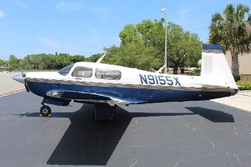 A side view of the white and blue aircraft with tail number N9155X.