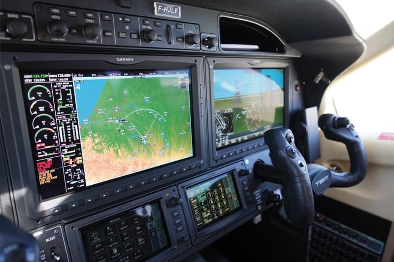 The aircraft's cockpit features a Garmin avionics suite.