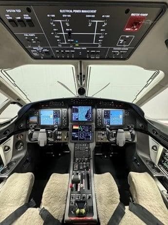 View of the cockpit instrument panel and electrical power management system in the ceiling.