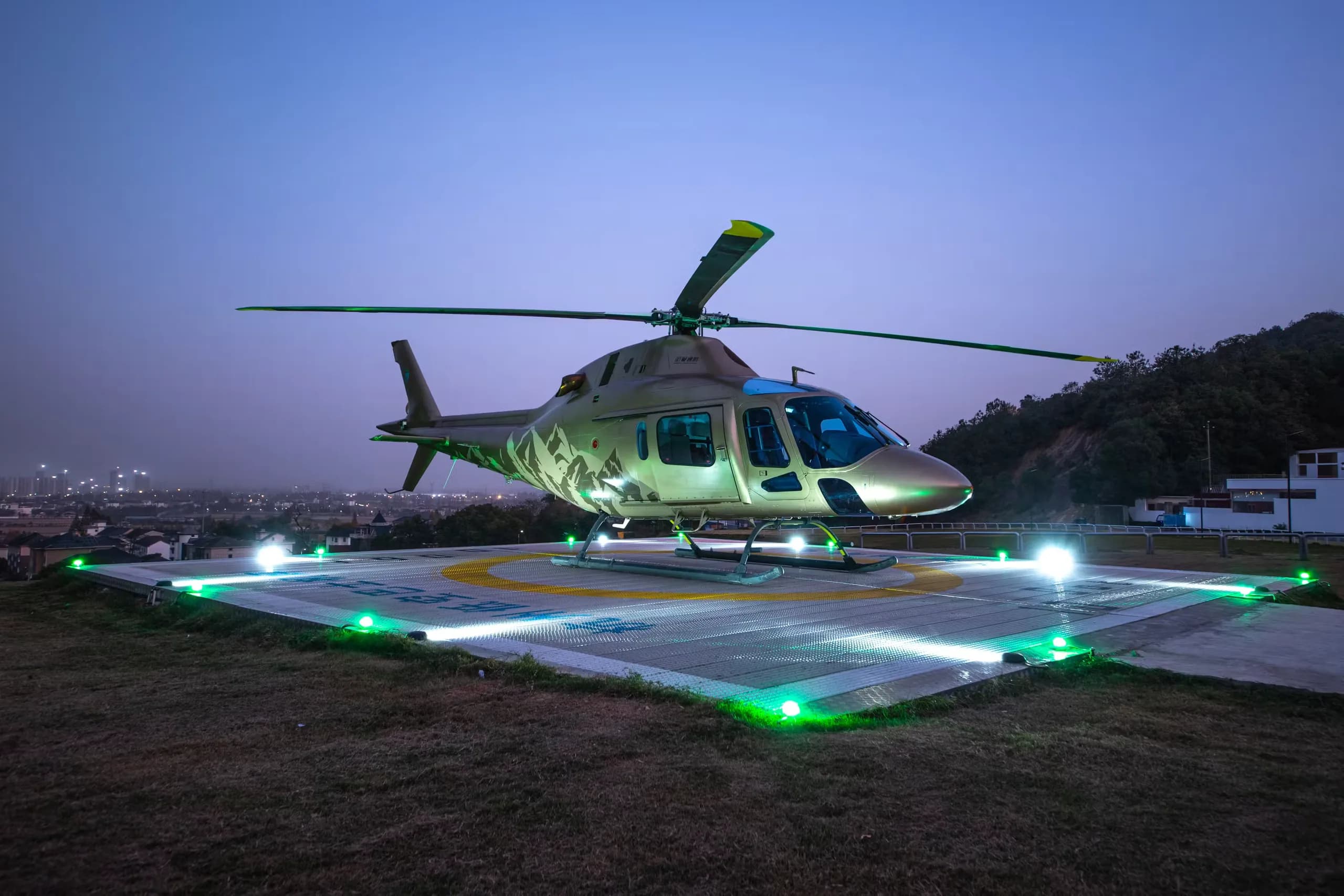 A B-704A helicopter is parked on a helipad at night.