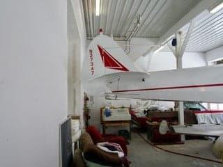 The tail of the aircraft N27347 is visible inside a hangar.