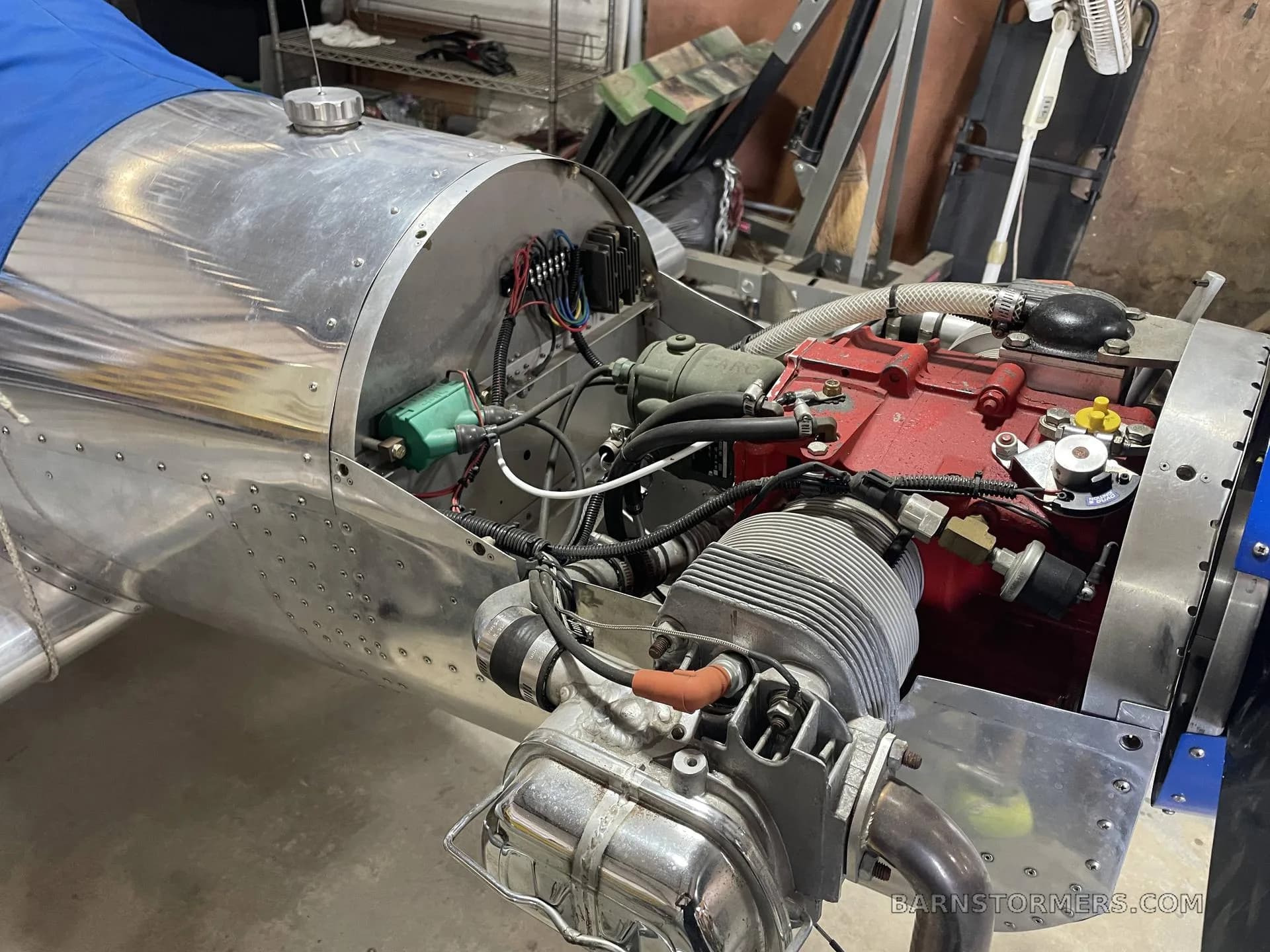 A close-up view of the aircraft's exposed engine, showing the red engine block and various components.