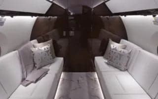A view of the aircraft's interior with white sofas and a patterned carpet.