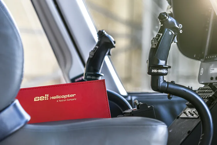 Close-up of the cockpit controls and a Bell Helicopter manual.