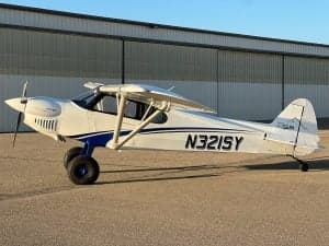 N321SY is a white and blue CubCrafters XCub parked on the tarmac.