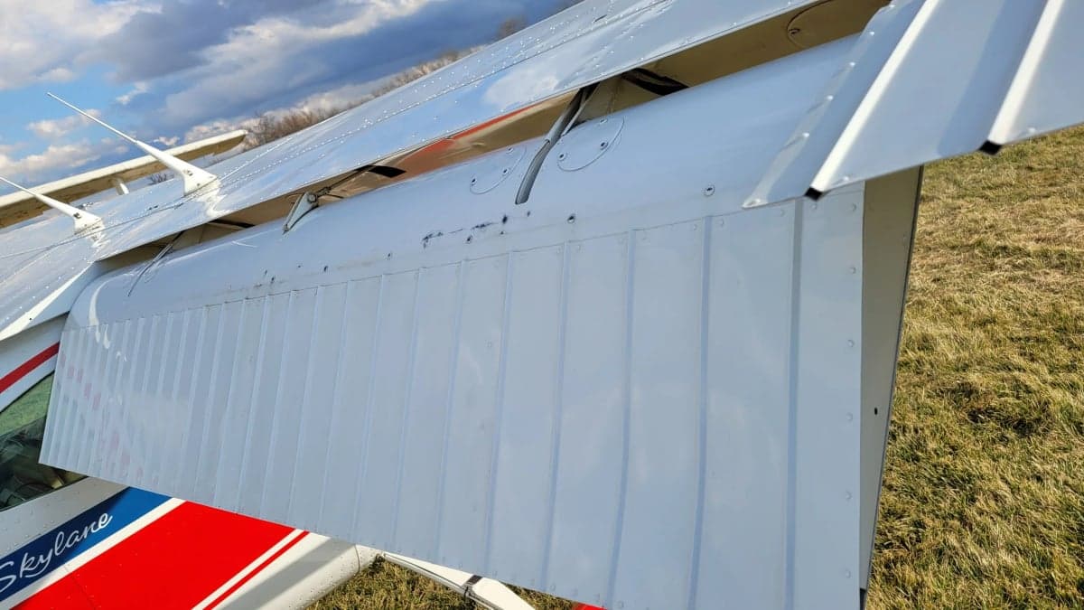 A close-up of the wing flaps of the Cessna Skylane with red, white, and blue paint scheme.