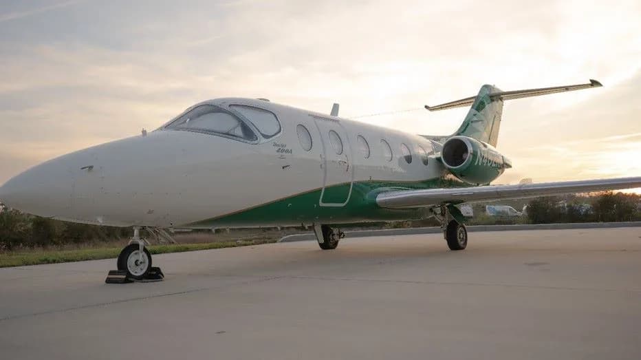 Beechcraft Premier 400A aircraft parked on the tarmac with a green and white paint scheme.