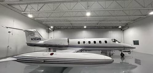 A Learjet with tail number N35WB parked in a hangar.