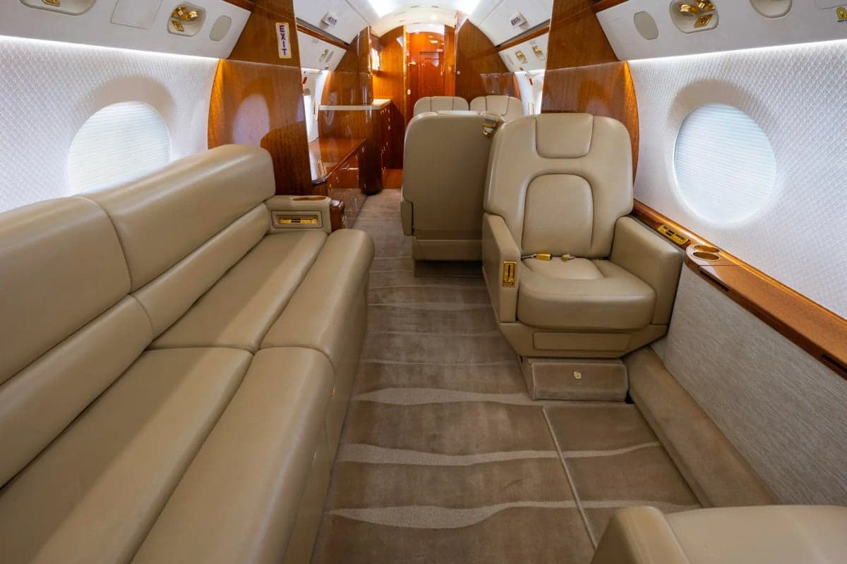 Gulfstream G450 cabin interior with a beige leather couch and seat.