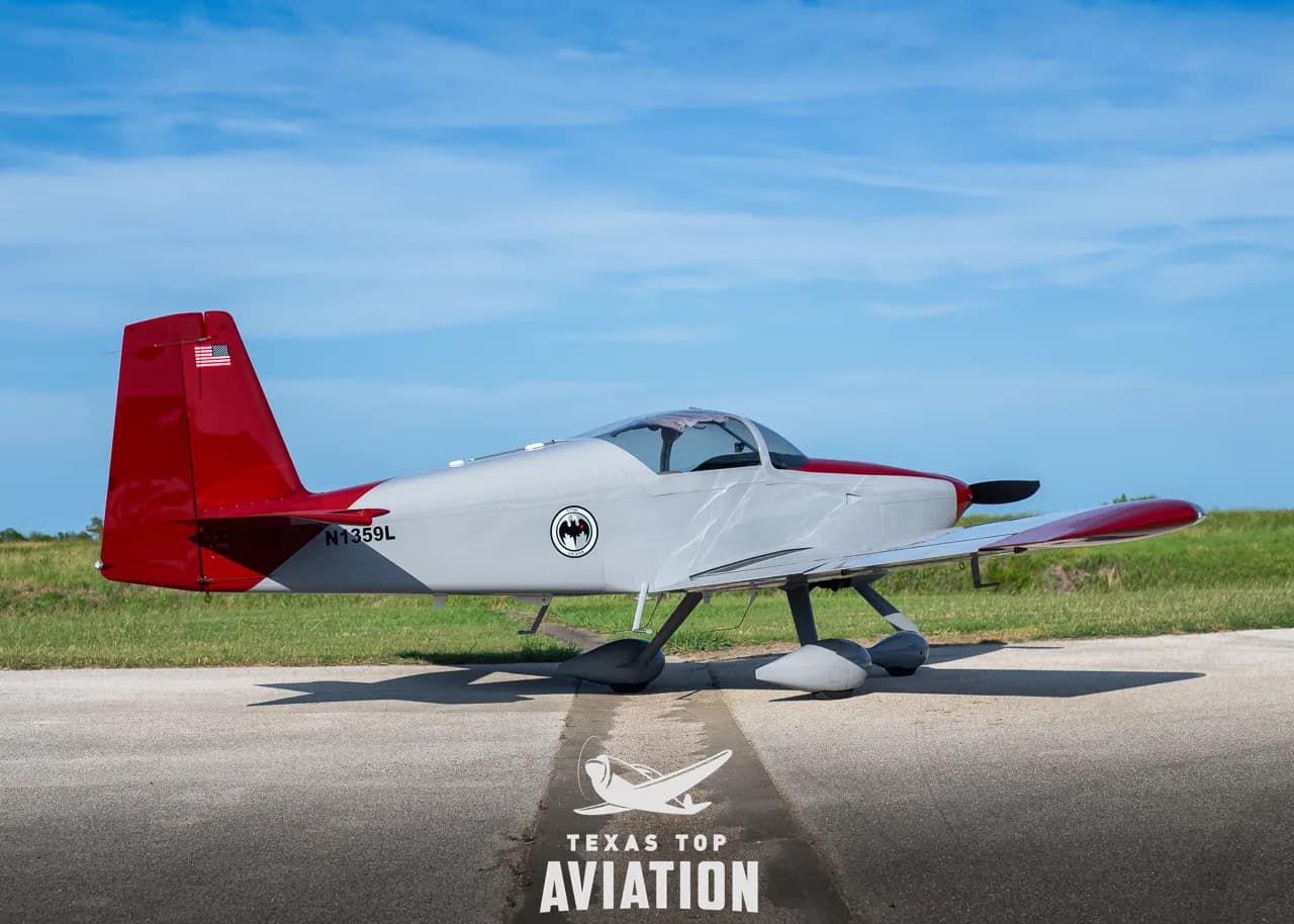 A full side view of the gray and red single-engine aircraft, N1359L, parked on a tarmac.