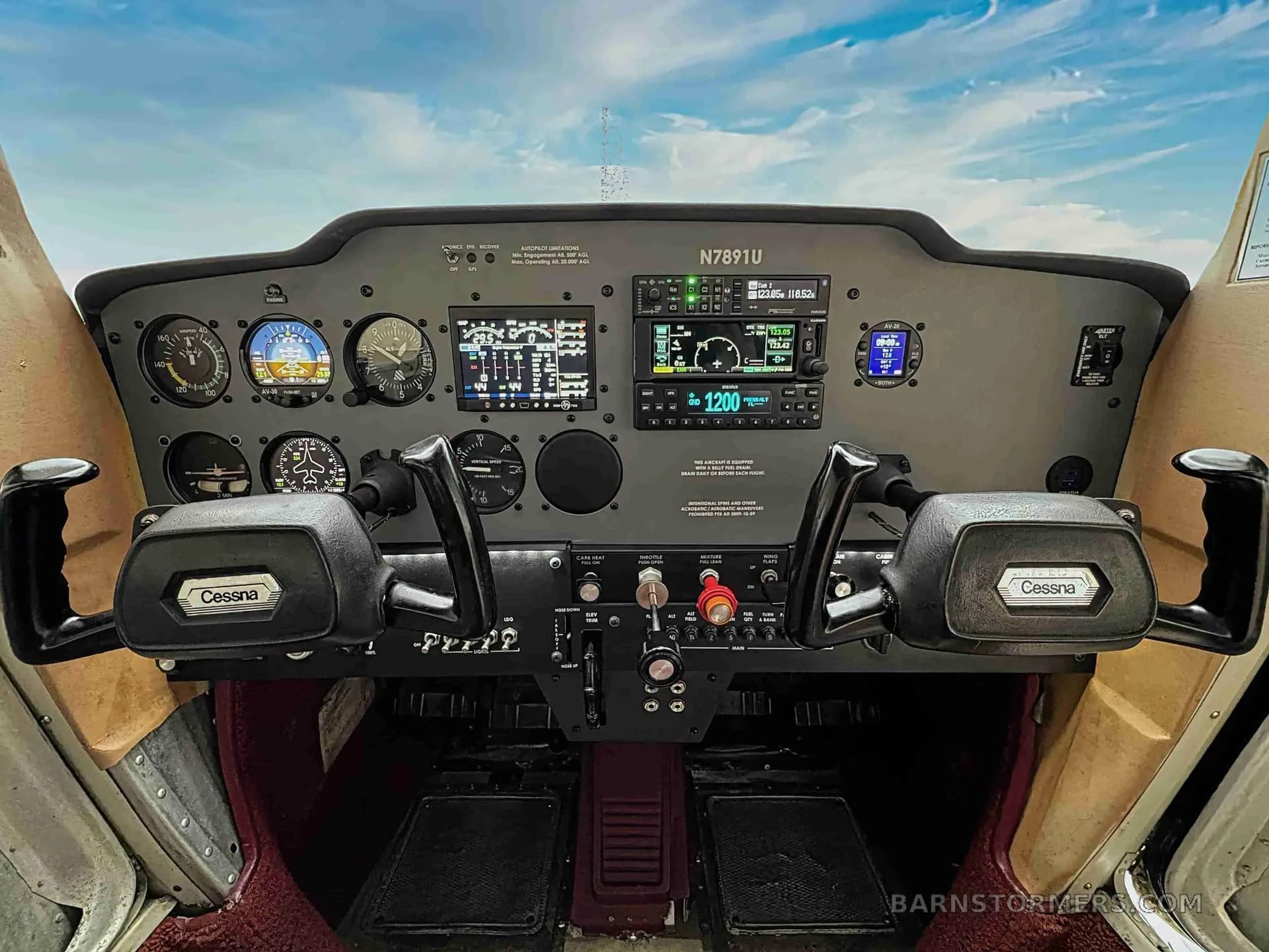 The cockpit of a Cessna N7891U aircraft showing the instrument panel with analog gauges and modern digital displays.