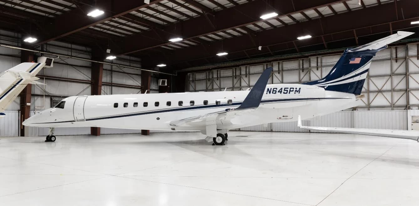 Side view of the N645PM Embraer Legacy 450 in a hangar.