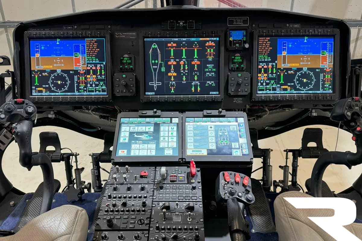 A modern helicopter cockpit with multiple digital displays and control panels.