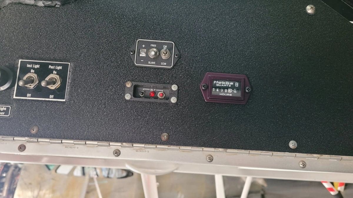Close-up of the instrument panel switches and Hobbs meter inside the Aviat Aircraft Husky A-1B aircraft.