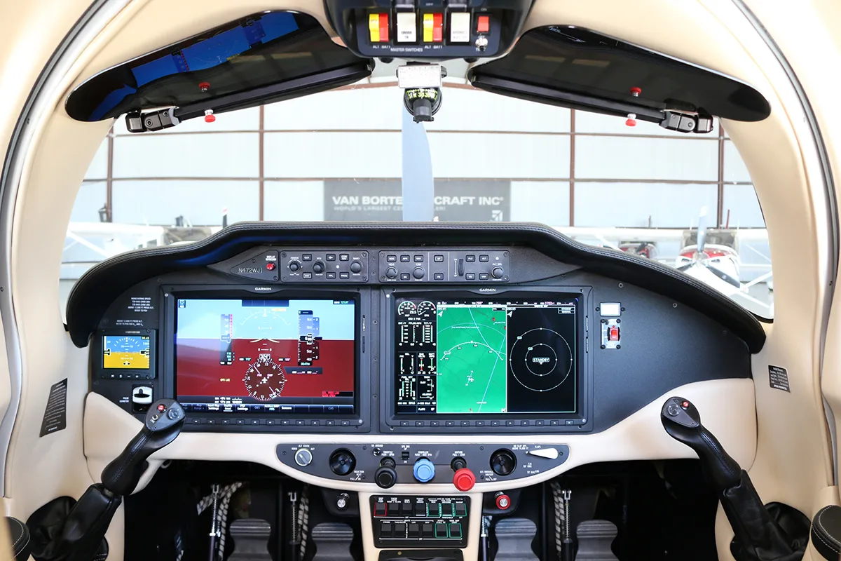 The cockpit features a modern glass panel with two large display screens and dual side-stick controls.