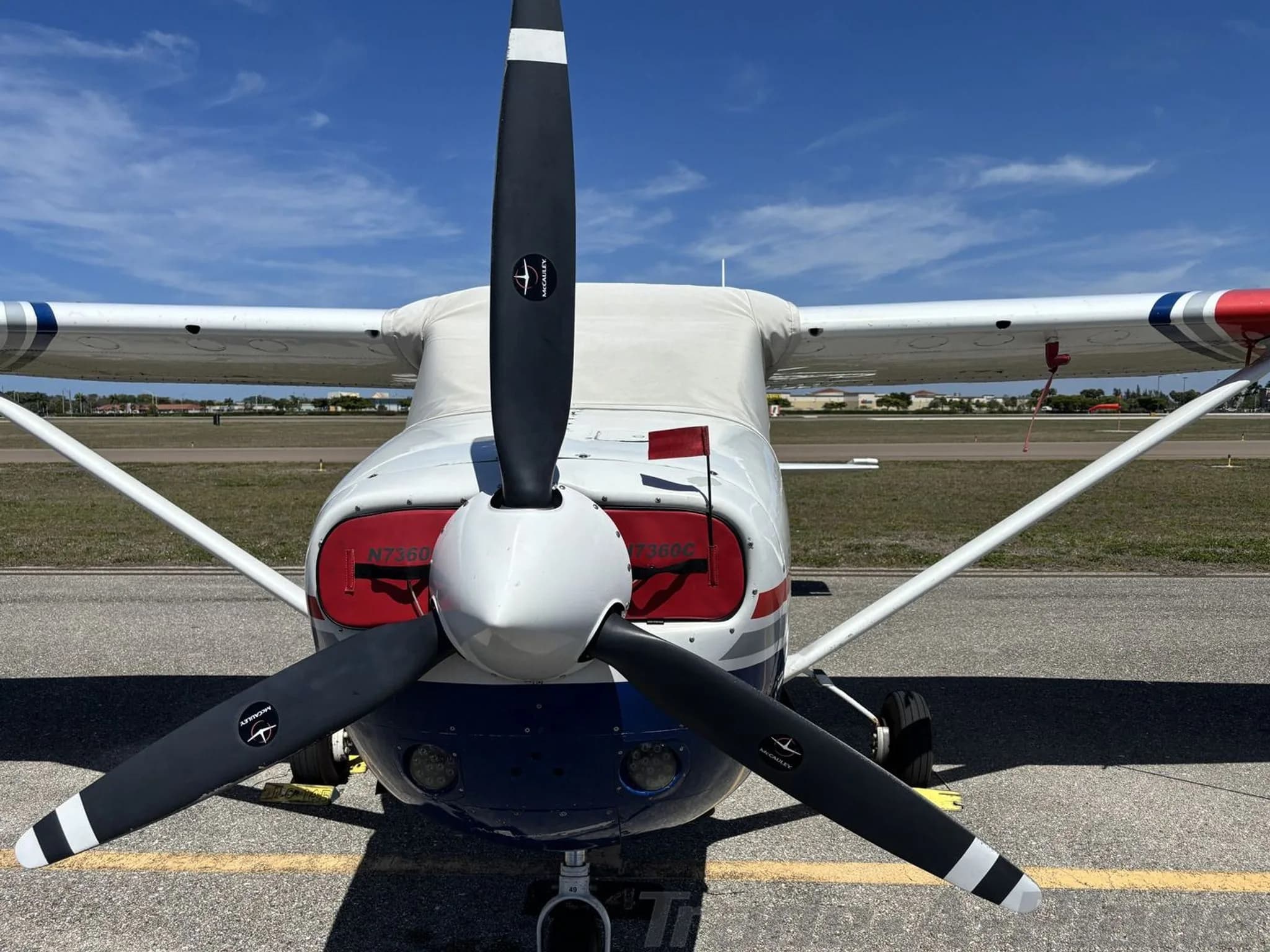 Close-up front view of the propeller and nose of Cessna N7360C, with engine covers on.