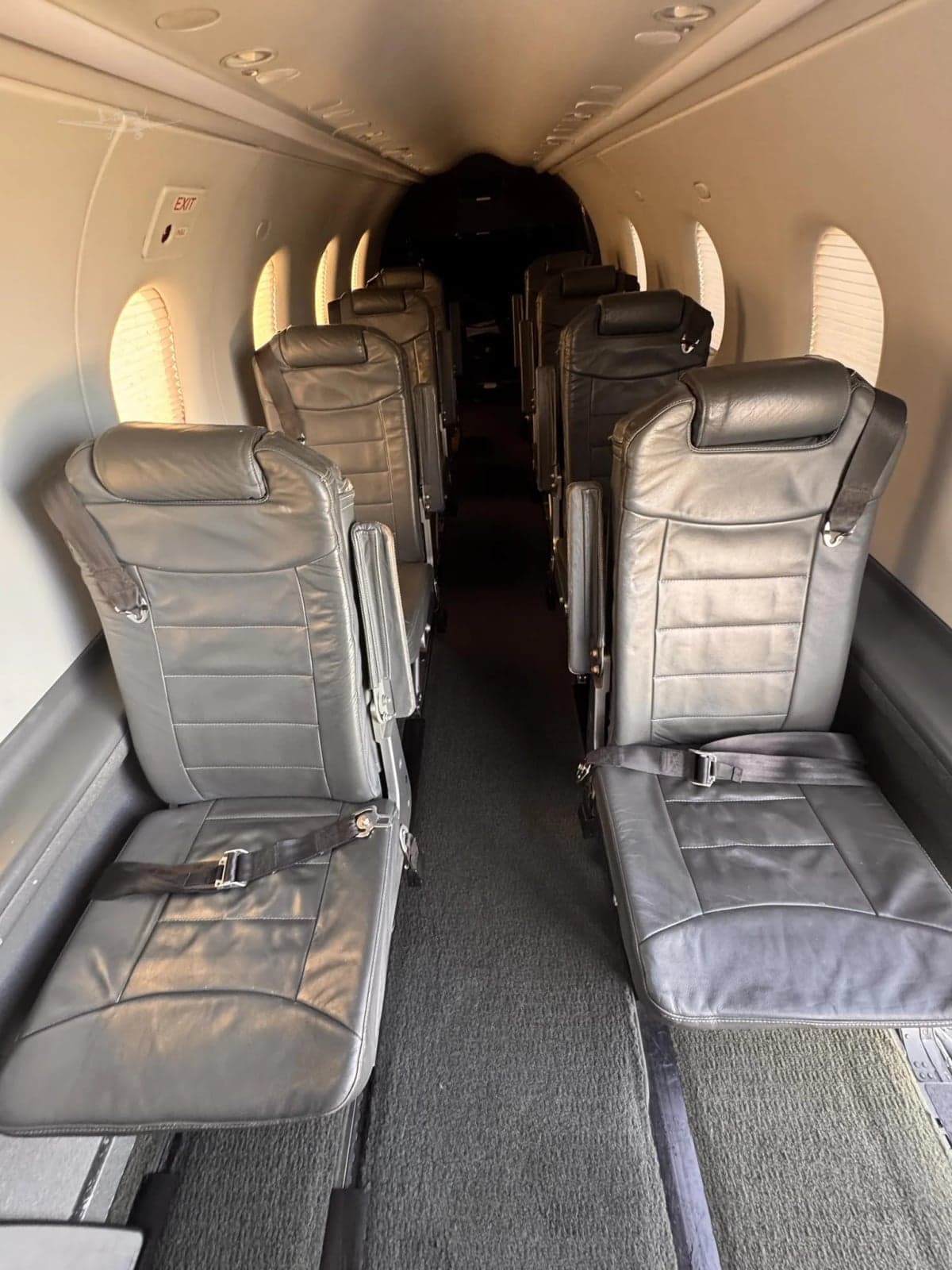 Interior view of the aircraft cabin, showing the seating arrangement and carpet.